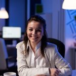 close-up-portrait-business-woman-smiling-camera-after-drinking-cup-coffee-sitting-desk-business-office-late-night-scaled.jpg
